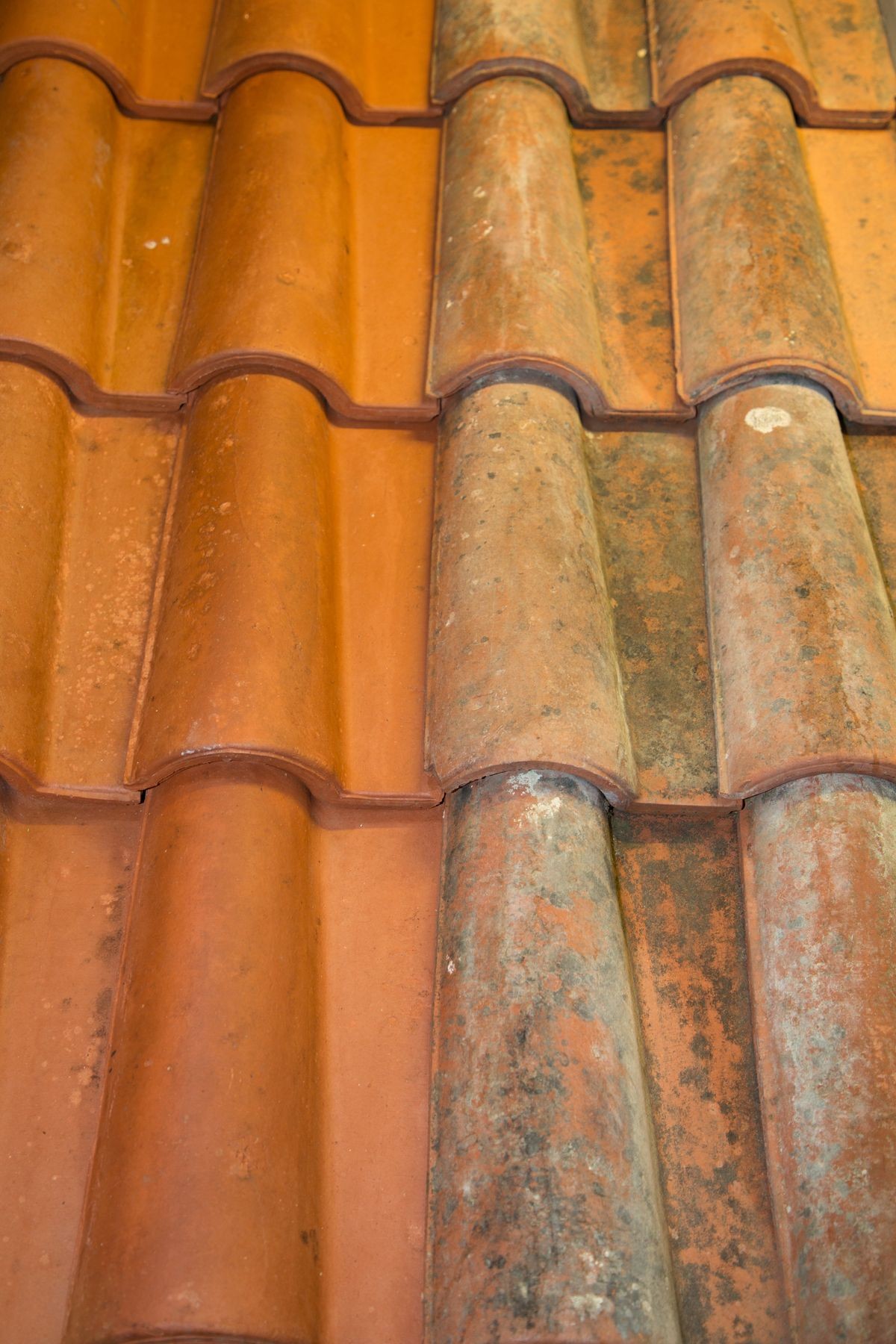 Old and new roof tiles side by side clean and dirty
